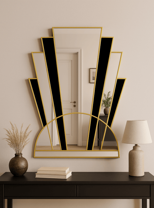 Decorative mirror with black and gold frame on a wall above a dark console table.
