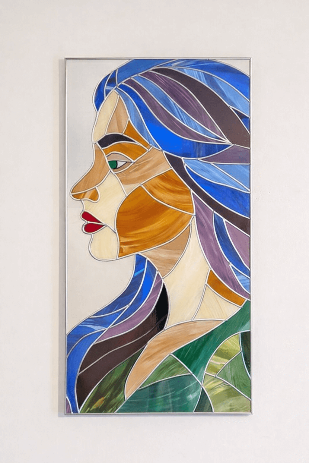 Modern stained glass style wall art featuring a colourful abstract portrait of a woman in profile. This vertical framed artwork showcases bold geometric shapes in rich blue, purple, green, and warm amber tones, with striking red lips and a green eye. The contemporary cubist-inspired design adds elegance and sophistication to living rooms, bedrooms, offices, or gallery walls. A vibrant statement piece perfect for modern home décor, art collectors, and unique gift ideas. Silver