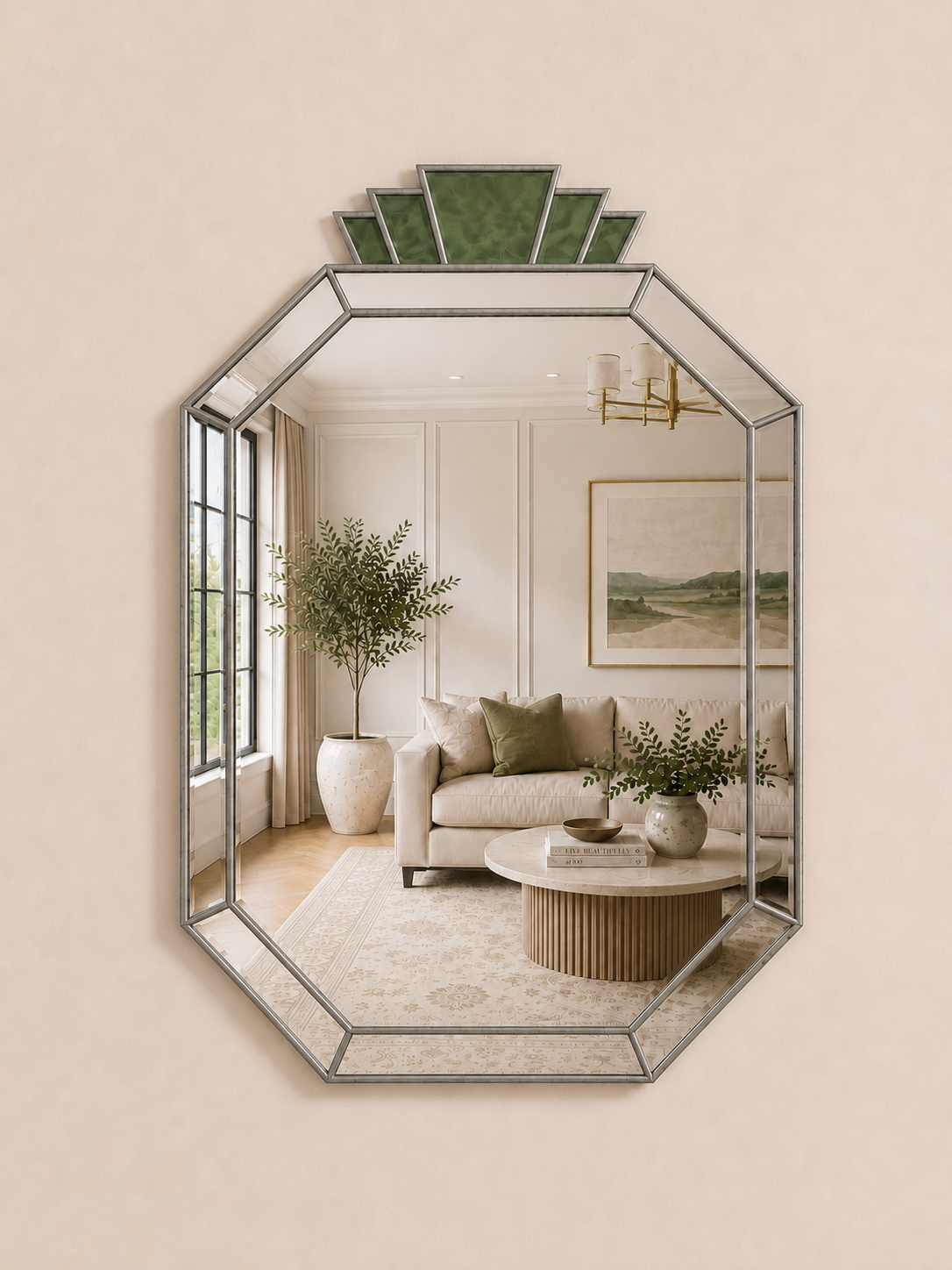 An octagonal wall mirror with a silver-toned metal frame and a green geometric fan-shaped top detail, shown mounted on a beige wall. The mirror reflects a styled living room interior with a sofa, plants, and a coffee table.
