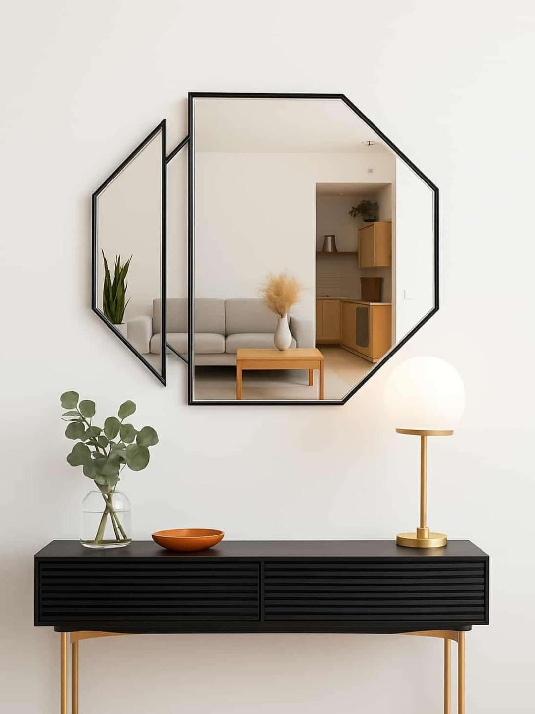 Modern interior design with a black console table, geometric mirror, and decorative items.
