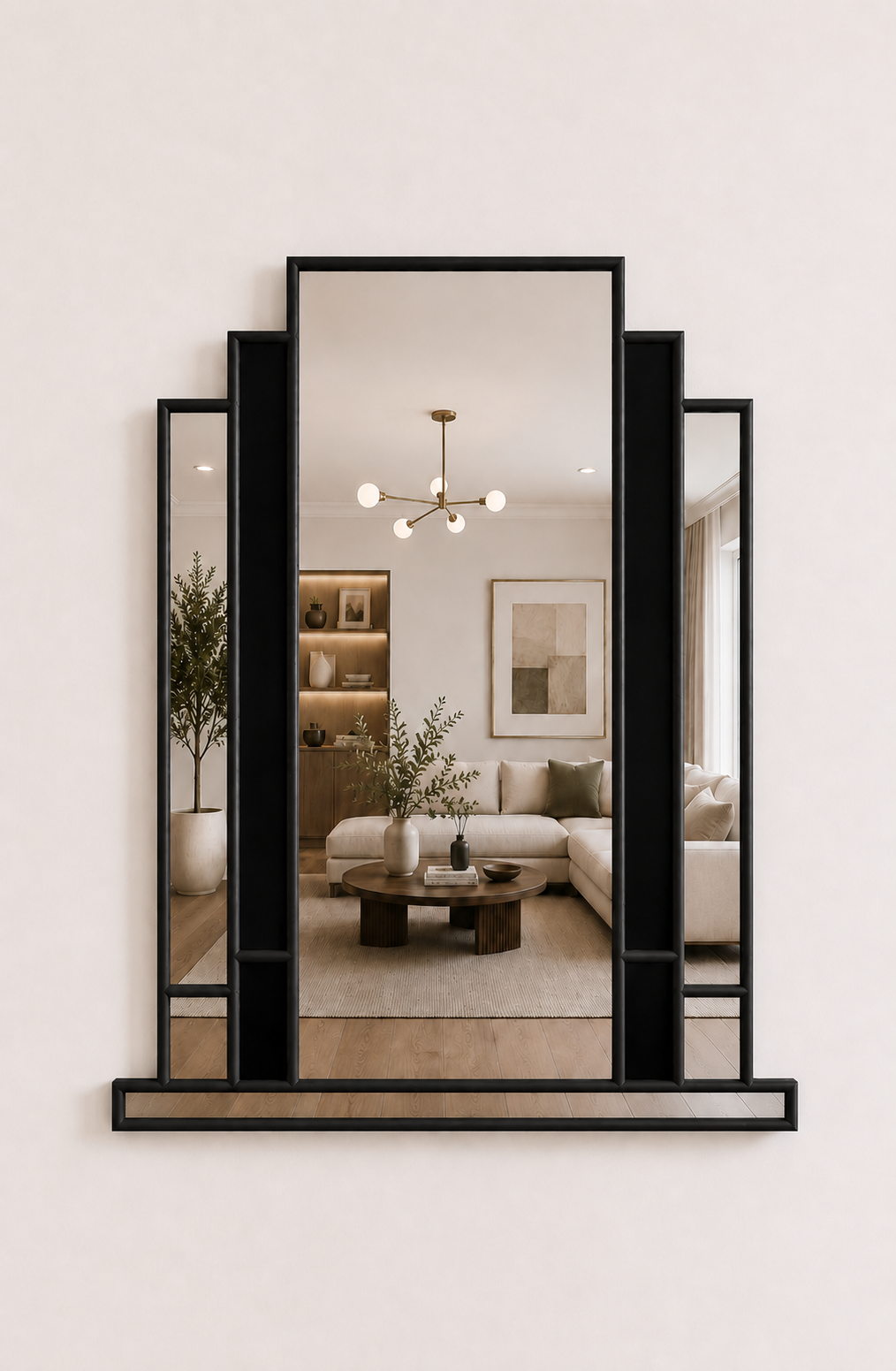 A modern black-framed wall mirror with a central tall panel and two flanking angled panels, mounted on a light beige wall. The mirror reflects a styled living room interior.