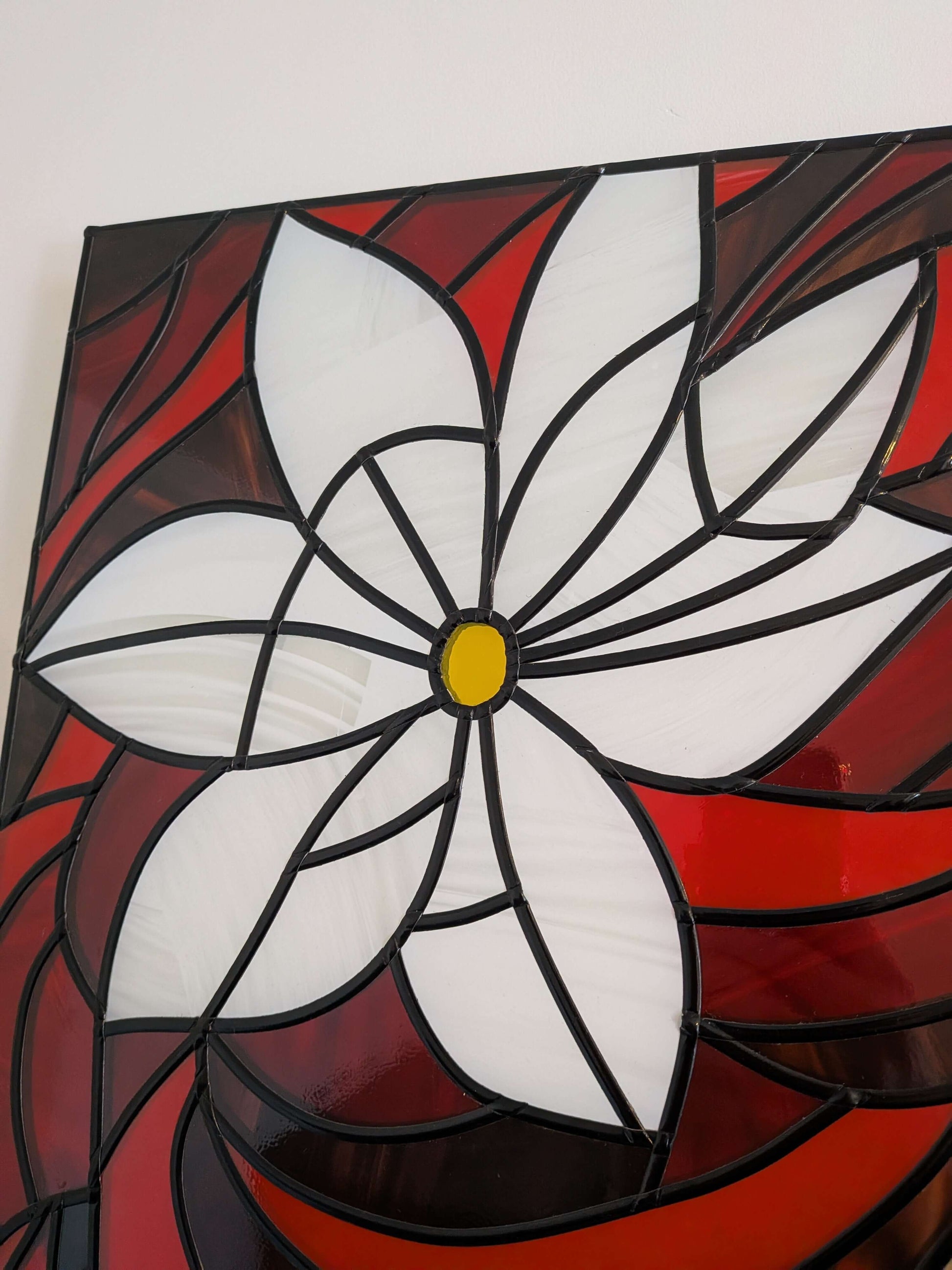 Stained glass panel with a white flower design on a red background