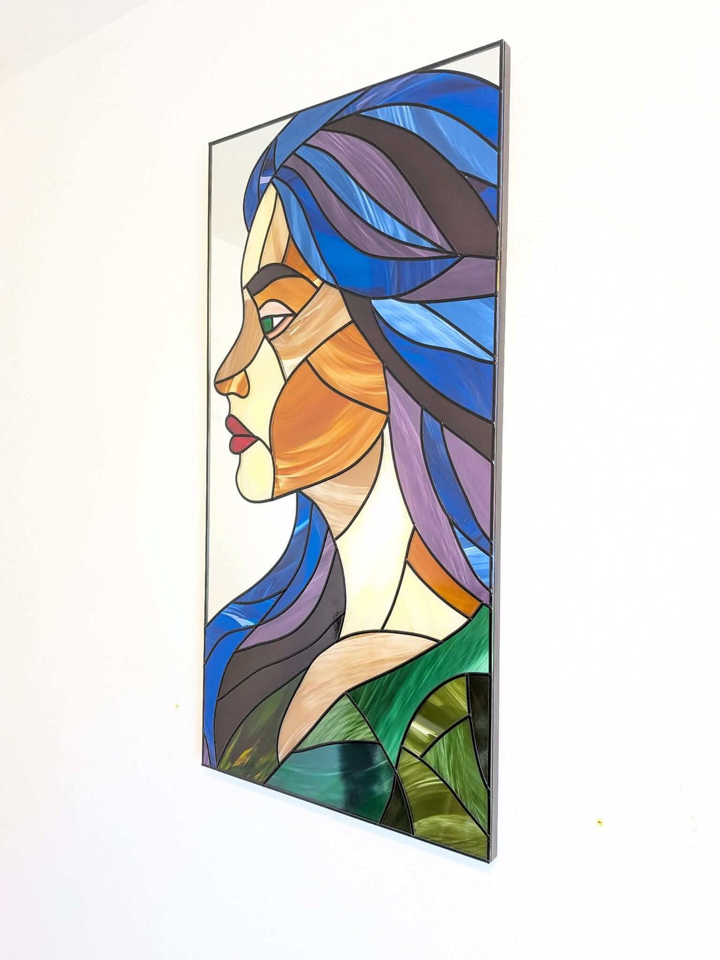 Modern stained glass style wall art featuring a colourful abstract portrait of a woman in profile. This vertical framed artwork showcases bold geometric shapes in rich blue, purple, green, and warm amber tones, with striking red lips and a green eye. The contemporary cubist-inspired design adds elegance and sophistication to living rooms, bedrooms, offices, or gallery walls. A vibrant statement piece perfect for modern home décor, art collectors, and unique gift ideas.