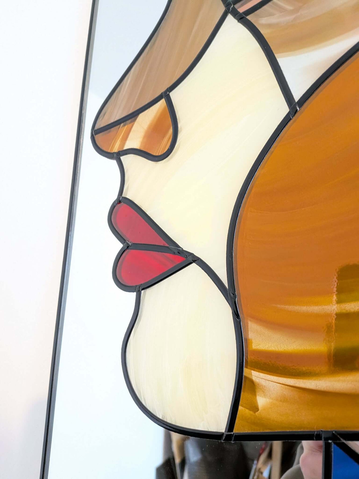 Modern stained glass style wall art featuring a colourful abstract portrait of a woman in profile. This vertical framed artwork showcases bold geometric shapes in rich blue, purple, green, and warm amber tones, with striking red lips and a green eye. The contemporary cubist-inspired design adds elegance and sophistication to living rooms, bedrooms, offices, or gallery walls. A vibrant statement piece perfect for modern home décor, art collectors, and unique gift ideas.