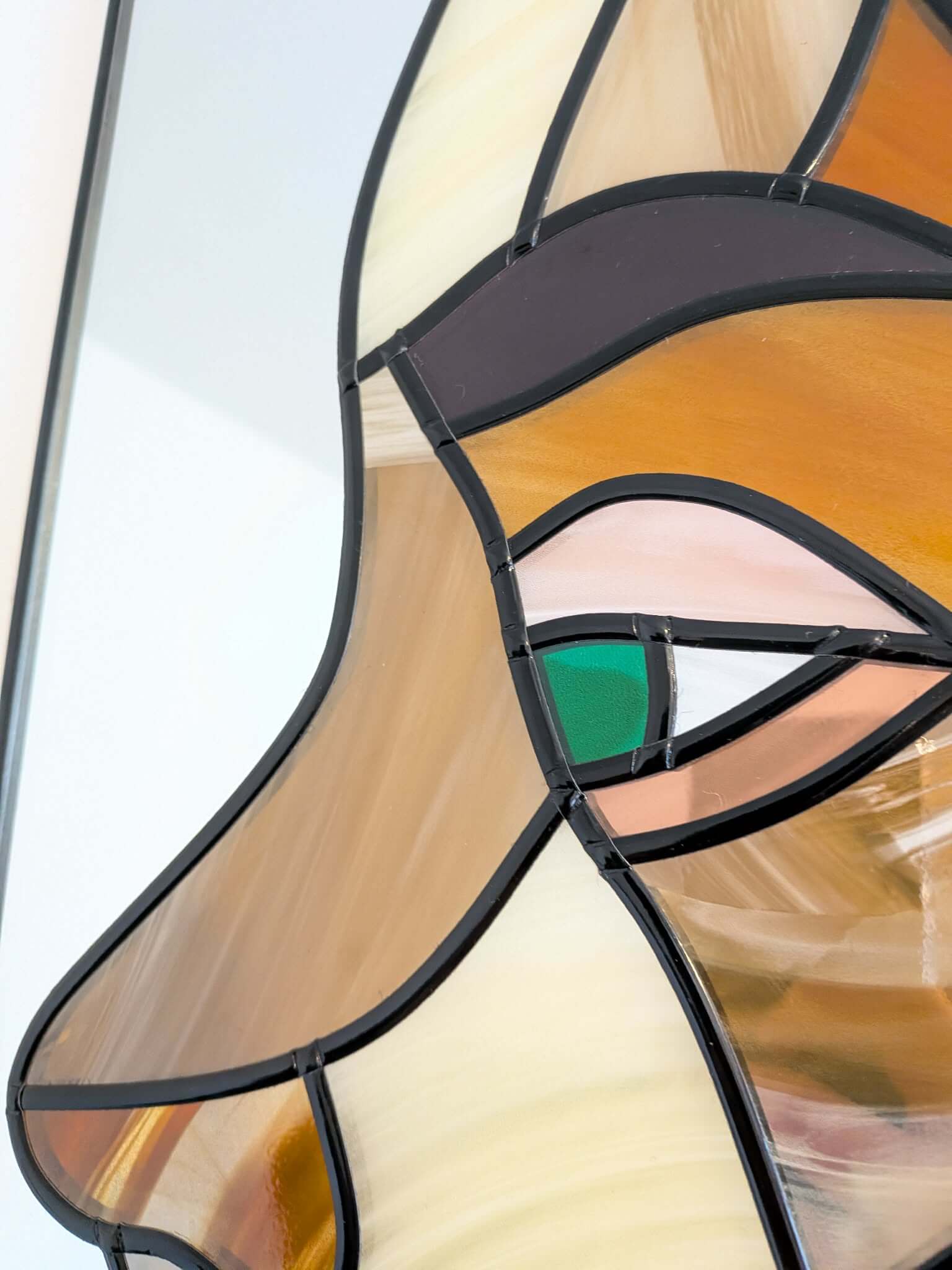 Modern stained glass style wall art featuring a colourful abstract portrait of a woman in profile. This vertical framed artwork showcases bold geometric shapes in rich blue, purple, green, and warm amber tones, with striking red lips and a green eye. The contemporary cubist-inspired design adds elegance and sophistication to living rooms, bedrooms, offices, or gallery walls. A vibrant statement piece perfect for modern home décor, art collectors, and unique gift ideas.